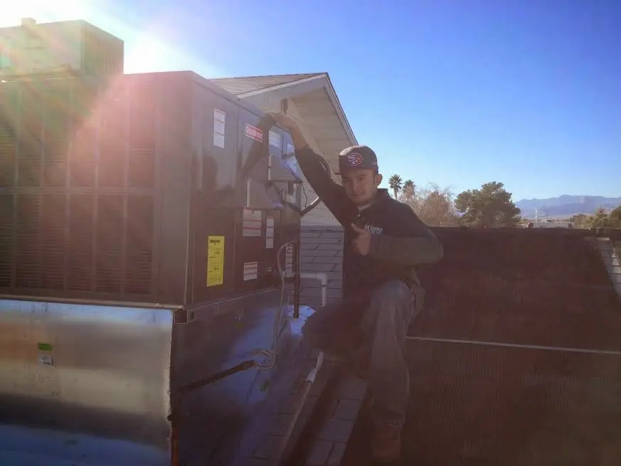 HVAC technician performing HVAC Inspection on a rooftop unit in Galesburg